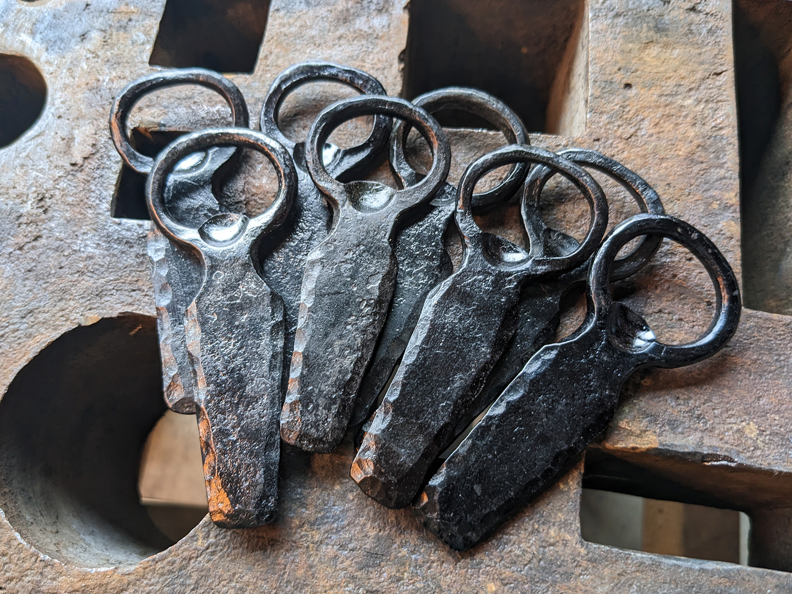 A pile of forged bottle openers.