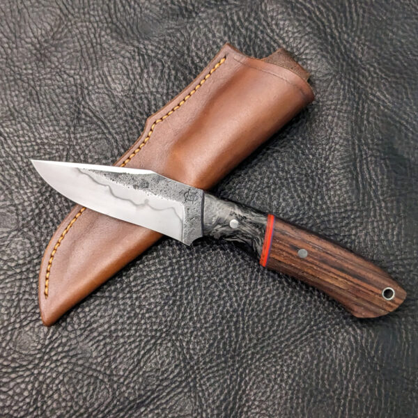 A recurve hunting knife with carbon fiber bolsters and cocobolo handle.