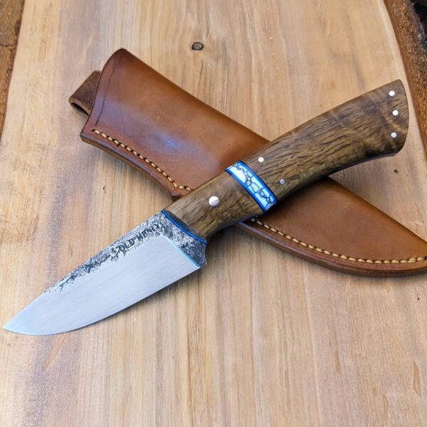 A hunting knife with a curly white oak handle.